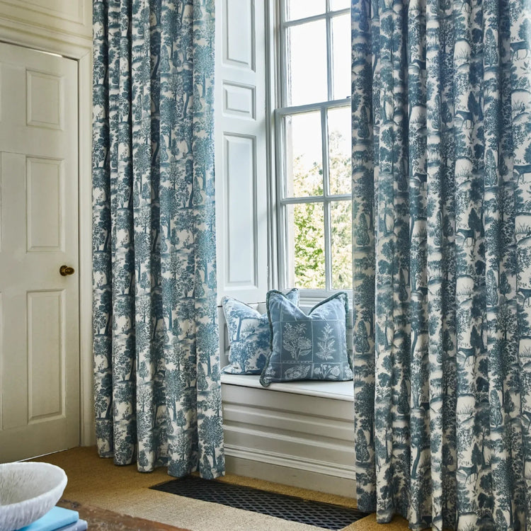 Blue patterned curtains beside a window seat