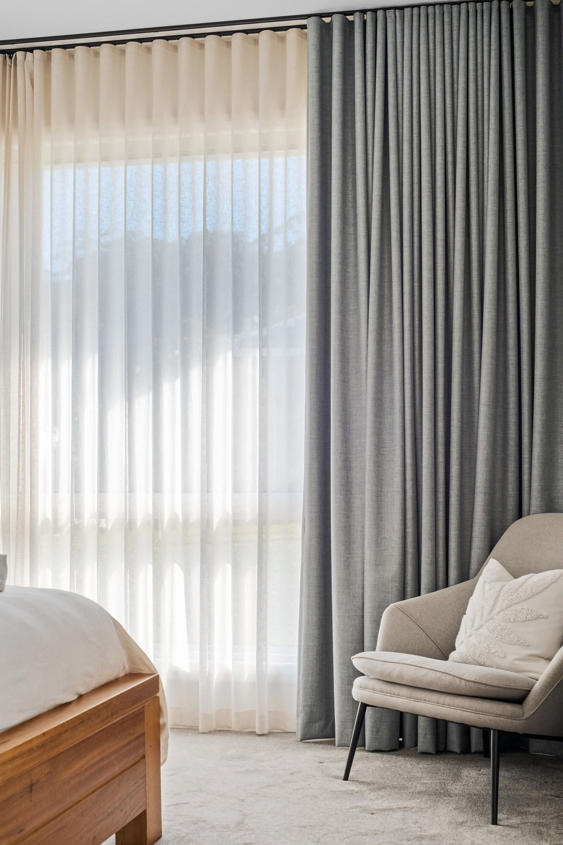 Neatly fitted grey curtains and sheer layers showing the track and even curtain folds