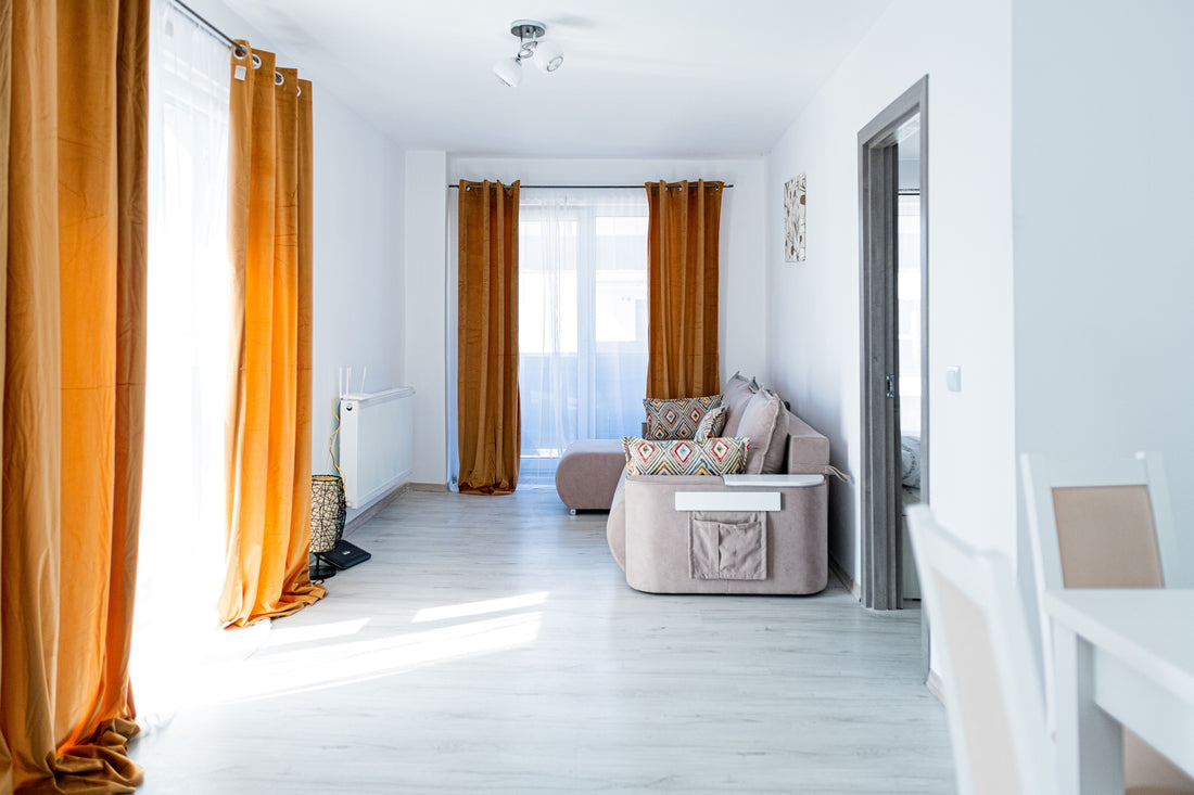 Ochre curtains standing out against bright white walls and a pale floor