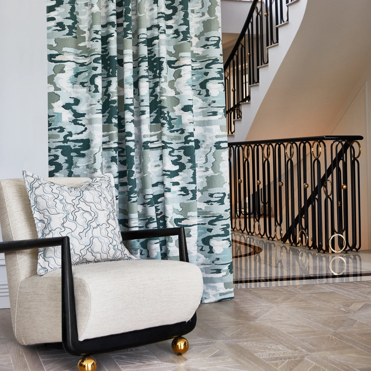 Green abstract curtains alongside a sculptural armchair and a quiet neutral wall