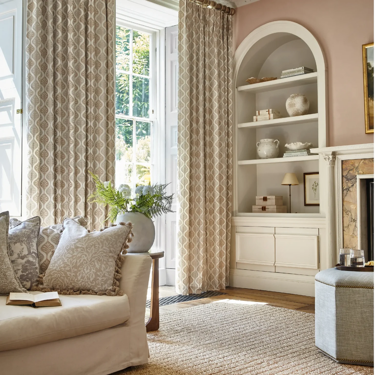 Patterned neutral curtains beside a cream sofa and coordinated cushions in a sitting room