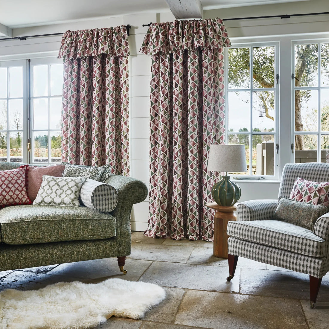 Rose and green patterned curtains coordinated with green upholstery, checked furniture and patterned cushions